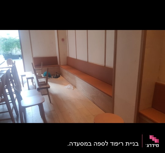 ספסל עץ מובנה עם ריפוד דמוי עור בחלל מסחרי